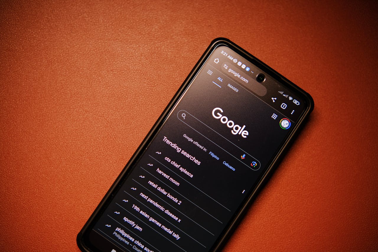about-01 A smartphone displaying Google Search trends on a table at night.